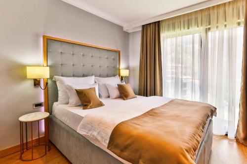 a bedroom with a large bed and a large window at Hotel Lusso Mare by Aycon in Budva