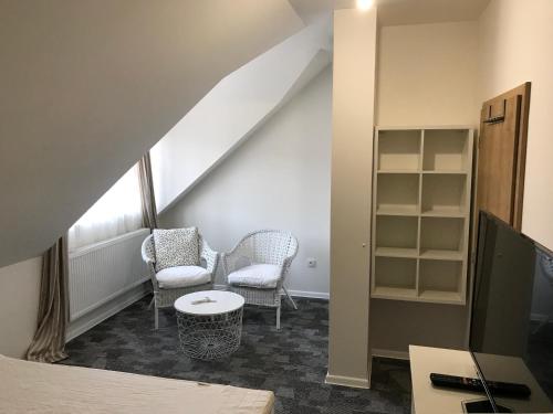 a attic room with two chairs and a table at Rezidence Věstonice in Horní Věstonice