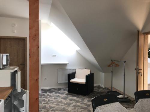 a living room with a white chair and a white ceiling at Rezidence Věstonice in Horní Věstonice