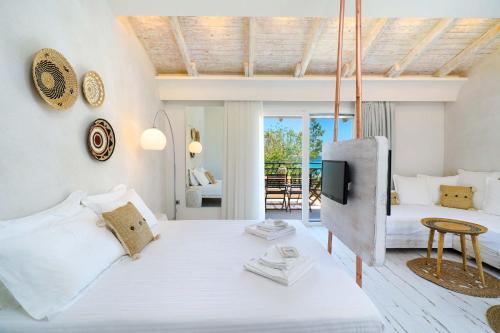 Studios Aigaio في سكالا بوتامياس: غرفة نوم بيضاء مع سرير وتلفزيون