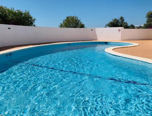 a large swimming pool with blue water at Villa Tara Christina in Carvoeiro
