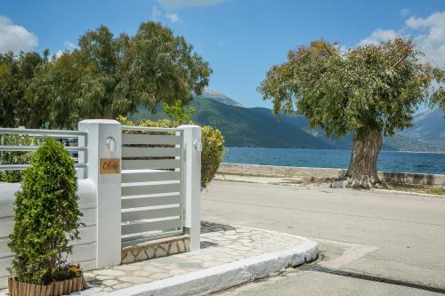 a white fence next to a road and a lake at Olvio Living by the Sea in Sami