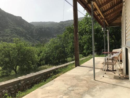 a porch of a house with a view of the mountains at Thanasis house in Dhimitsana