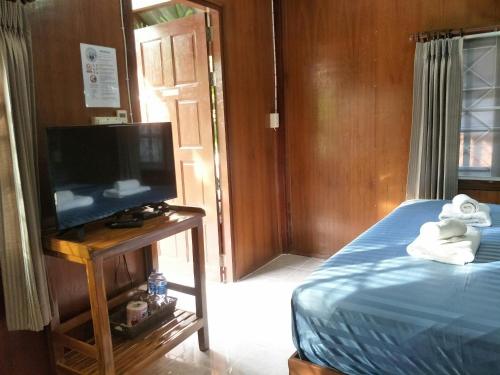a bedroom with a bed and a tv on a table at BeauBo Beach in Baan Tai