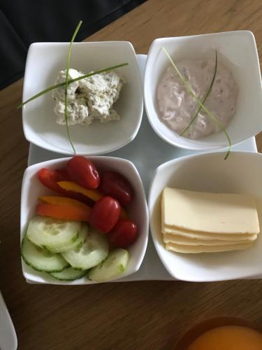 four bowls of food with cheese and vegetables on a table at Ambiente in Flachau