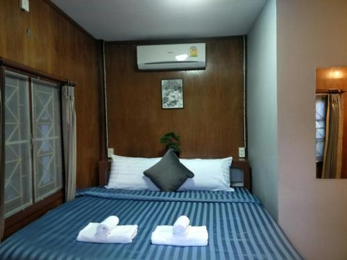 a bedroom with a bed with two towels on it at BeauBo Beach in Baan Tai