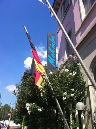two flags flying outside of a building with a sign at Mokinba Hotels Montebianco in Milan
