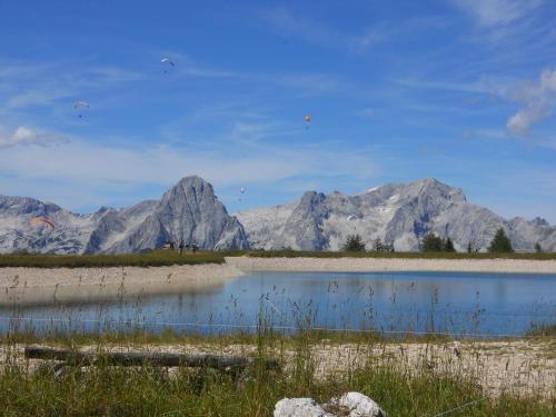 a mountain range with kites flying over a body of water at Pension Pichler in Hinterstoder