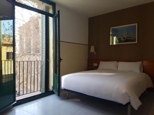 a bedroom with a bed and a large window at El Jardi in Barcelona