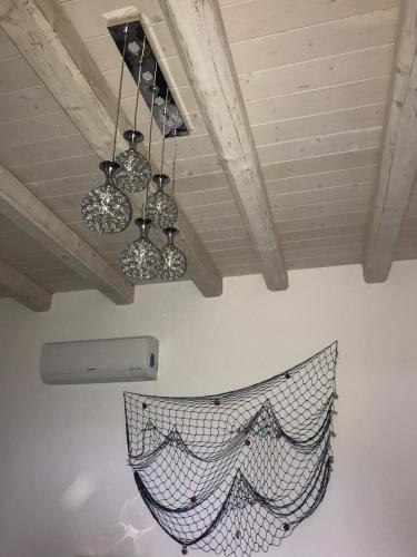 a net hanging from a ceiling with two chandeliers at La Perla Scala dei Turchi in Realmonte