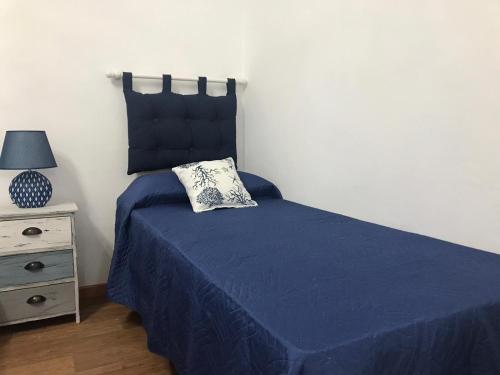 a bedroom with a blue bed with a pillow on it at La Perla Scala dei Turchi in Realmonte