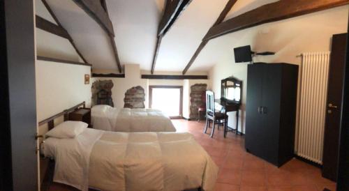 a bedroom with two beds and a television in it at Locanda dei Tigli in Trivero