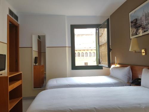 a hotel room with two beds and a window at El Jardi in Barcelona