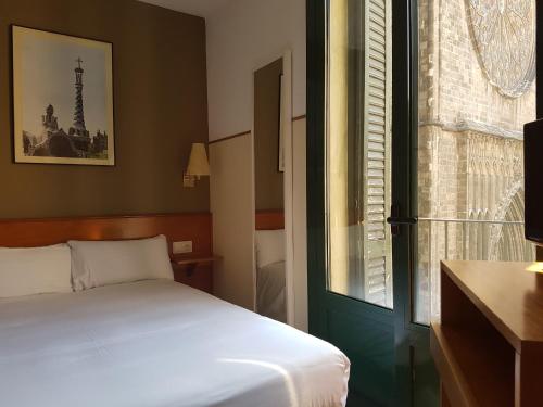 a small bedroom with a bed and a window at El Jardi in Barcelona