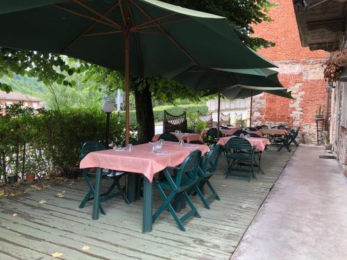 een groep tafels en stoelen onder een paraplu bij Locanda dei Tigli in Trivero