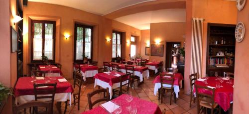 Un restaurante con mesas y sillas rojas en una habitación. en Locanda dei Tigli, en Trivero