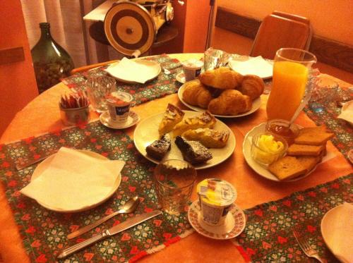 una mesa cubierta con platos de comida y zumo de naranja en Locanda dei Tigli en Trivero