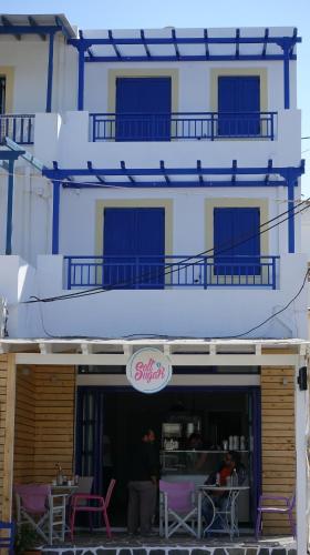 a building with tables and chairs in front of a restaurant at Sea Urchin Apartments 2nd floor in Agia Pelagia Kythira