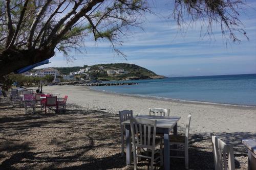 a table and chairs on a sandy beach at Sea Urchin Apartments 2nd floor in Agia Pelagia Kythira