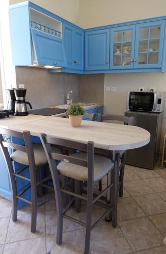 a kitchen with a table and some blue cabinets at Sea Urchin Apartments 2nd floor in Agia Pelagia Kythira