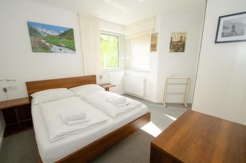 a bedroom with a bed and a table in it at Finest Apartments Glacier View by All in One Apartments in Kaprun