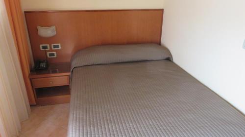 a small bed in a bedroom with a wooden headboard at Hotel Oasi Dei Discepoli in Orvieto