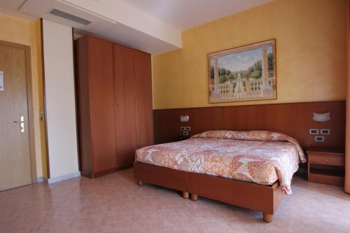 a bedroom with a bed and a painting on the wall at Hotel Oasi Dei Discepoli in Orvieto