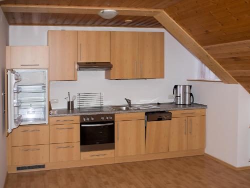 a kitchen with wooden cabinets and a refrigerator at Pension Pichler in Hinterstoder