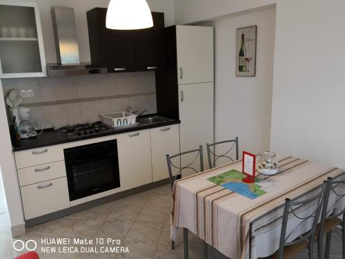 eine Küche mit einem Tisch und einem Herd Top-Backofen in der Unterkunft Apartmans Luce e Stella in Malinska