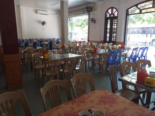 een eetkamer met tafels en stoelen en een eettafel bij Khách Sạn Hồng Tấn in Thương Xà (2)