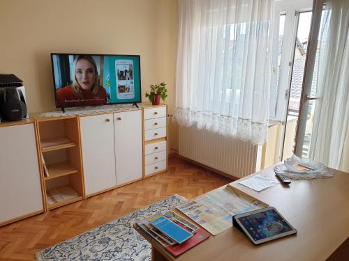 a living room with a table and a television on a dresser at Apartment Milena in Maribor