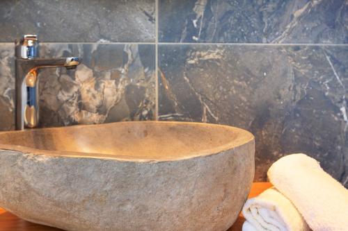 a stone sink with a faucet in a bathroom at 180 South Seaside Hotel in Thermisia