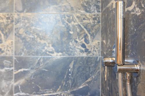 a close up of a metalaucet in a bathroom at 180 South Seaside Hotel in Thermisia