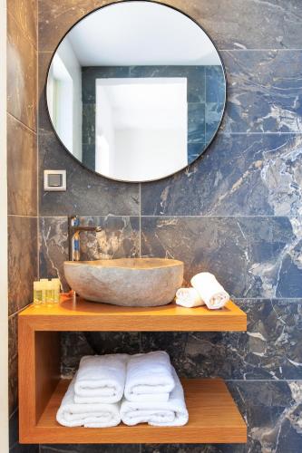 a bathroom with a sink and a mirror and towels at 180 South Seaside Hotel in Thermisia