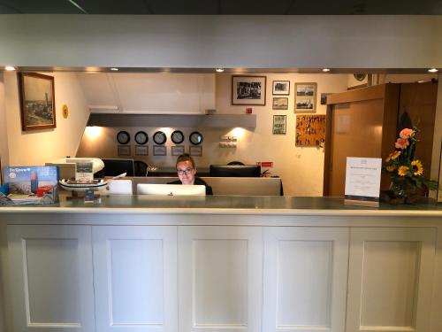 a woman sitting at a counter in a office at Hotel Nap in West-Terschelling