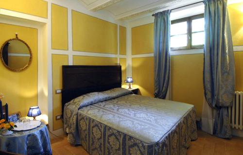 a bedroom with a bed and a window at Antica Sosta in San Quirico dʼOrcia