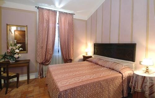 - une chambre avec un lit, une table et une fenêtre dans l'établissement Antica Sosta, à San Quirico dʼOrcia