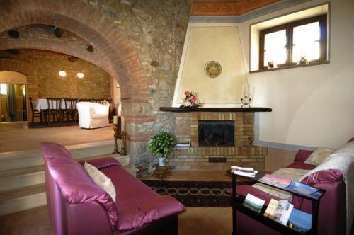 a living room with a couch and a fireplace at Antica Sosta in San Quirico dʼOrcia