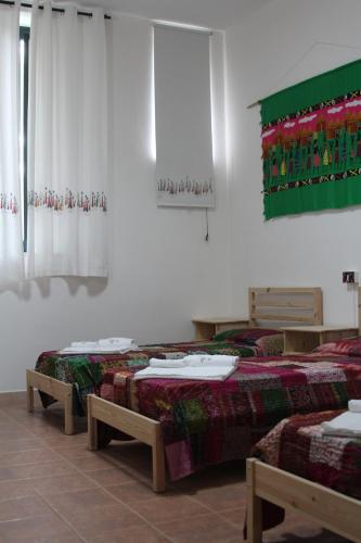 two beds sitting in a room with curtains at Beteyà Hostel Don Bosco in Catania