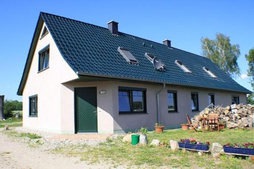 a white house with a gambrel roof at Ruegen_Fewo 259 in Berglase