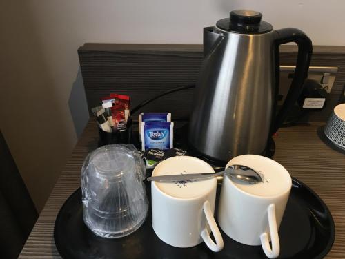 a table with a coffee pot and two cups on it at The Eaton Townhouse in London