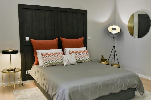 a bedroom with a large bed with orange pillows at Casa das Arcadas in Ponta Delgada