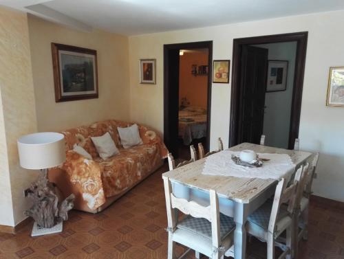 sala de estar con mesa y sofá en Appartamento Villa Edera, en Baja Sardinia