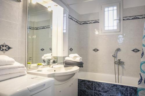 y baño blanco con lavabo y ducha. en Villa Alessandra, en Markópoulon