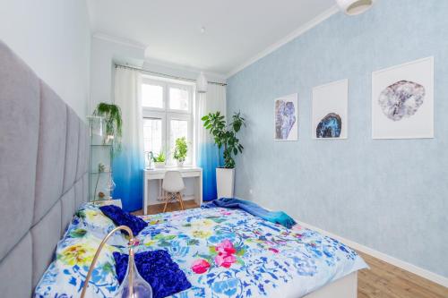 una camera da letto con un letto con una parete blu di Hello Apartments Chlebnicka a Danzica