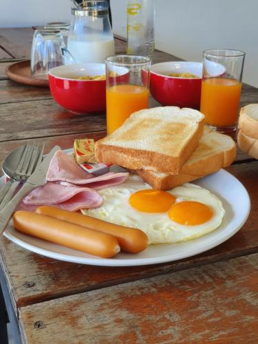 um prato de comida de pequeno-almoço com ovos, salsicha e torradas em Kanlaya Park em Mae Nam