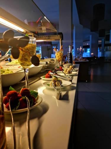 a buffet line with plates of food and wine glasses at Long Beach Hotel & Resort in Lóngos
