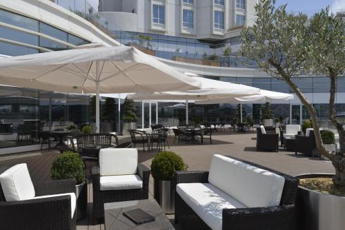 a patio with white umbrellas and tables and chairs at Wyndham Grand Istanbul Europe in Istanbul