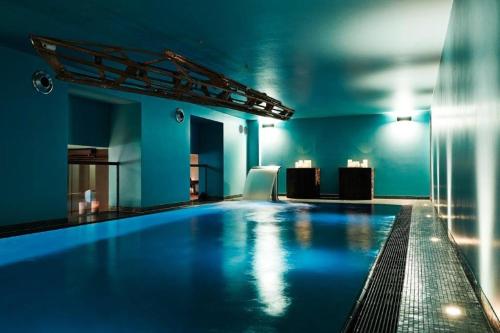 ドゥーダーシュタットにあるZum Löwen Design Hotel Resort & Spaの青い壁の客室内の大きなスイミングプール