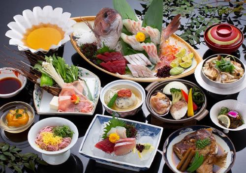 a table topped with different types of food at Wakayama Kada Onsen Kada Kaigetsu (ex. Azumaya Seaside Hotel) in Wakayama